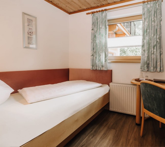 Bett im Einzelzimmer Standard im Hotel Garni Tannenhof in Flachau